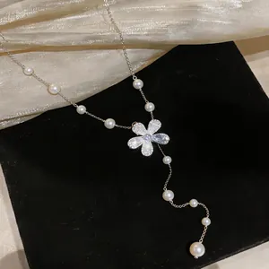Detailed macro shot of an elegant silver chain necklace with pearls and crystal flower