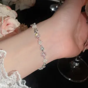 Elegante bracciale floreale in argento con perle e zirconi rosa su un polso femminile