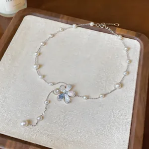 Detailed macro view showing the elegant pearl beaded necklace and flower pendant.