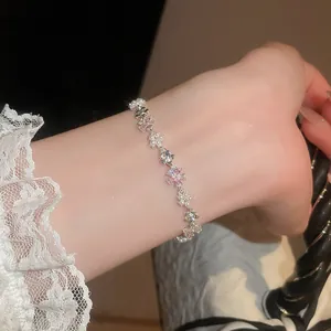 Elegante primo piano di un braccialetto a fiori con perle e zirconi rosa sul polso