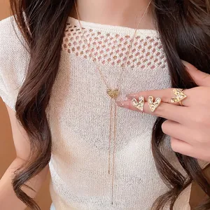 Elegant gold crumpled heart jewelry set including necklace, ring, and earrings on model