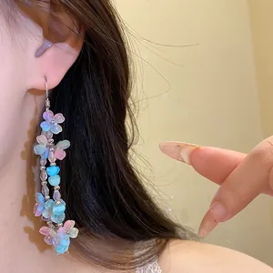 Detail of colorful resin flower tassel earrings worn by a model for a girlish look