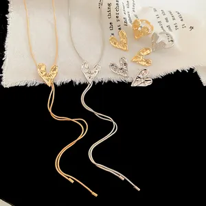 Detail view of textured wrinkled heart necklaces, rings, and earrings in gold and silver