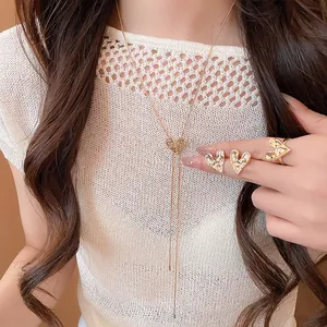 Close-up detail of vintage pleated gold heart necklace, earrings, and ring jewelry set on model