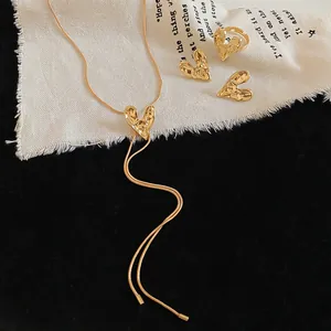 Macro view of gold wrinkled heart jewelry set including necklace ring and earrings
