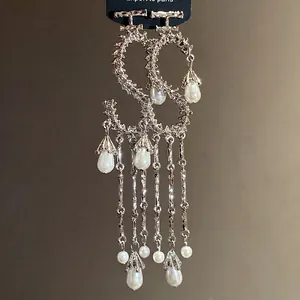 Eleganti orecchini a forma di S argento con nappe di perle e pendenti a goccia.
