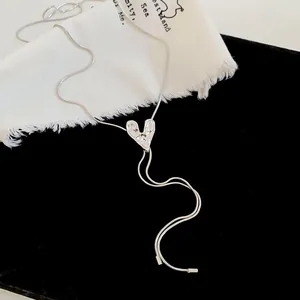 Detailed macro view of a silver heart pendant necklace with crinkle texture on black velvet