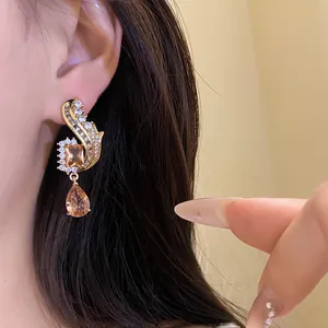 Primo piano di orecchini vintage con zircone champagne e dettagli dorati eleganti