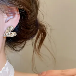 Close-up of minimalist crumpled silver heart stud earring for a premium look