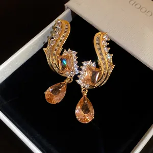Primo piano di orecchini vintage con pietre di zirconia a goccia color champagne