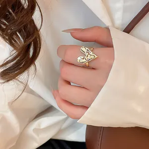 Close-up detail of a pleated heart-shaped gold ring with high-end luxury texture.