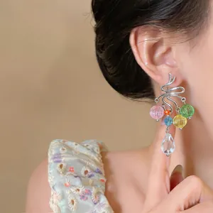 Primo piano di orecchini colorati a nappa in vetro stile coreano indossati da modella