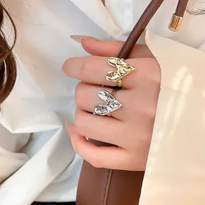 Close-up of unique crumpled heart rings in gold and silver showing metallic texture