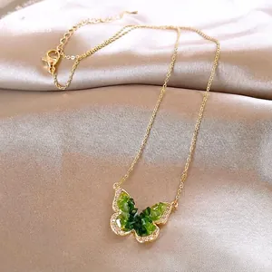 Elegant gold necklace with green gradient butterfly pendant and sparkling rhinestones