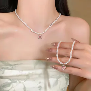 Exquisite detail view of French style pearl necklace and heart bracelet on model