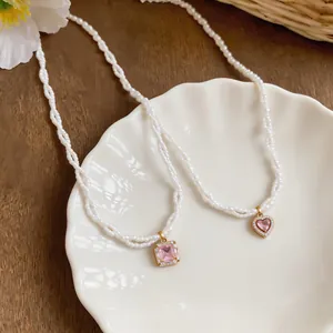 Close-up of French twisted pearl necklace with pink zircon heart and square pendants.