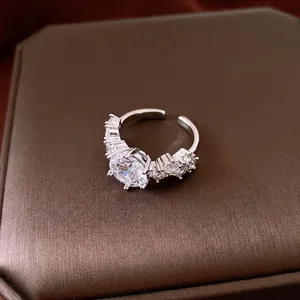Vintage silver-plated open ring with sparkling cubic zirconia stones displayed on brown box