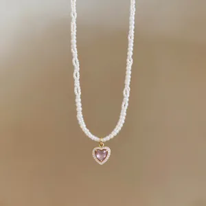 Close-up of elegant multi-strand pearl necklace with pink heart zircon pendant