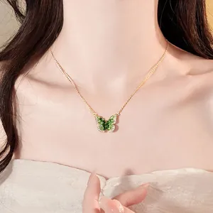 Elegant green gradient butterfly pendant necklace worn on a gold chain, detailed close-up view.