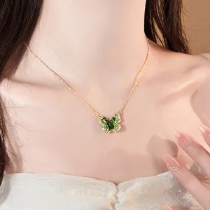 Detailed view of an elegant green gradient butterfly pendant necklace worn by a model