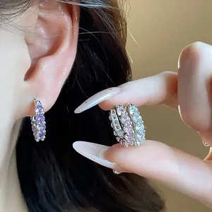 Detailed close-up view of sparkling zircon hoop earrings in purple, pink and white colors