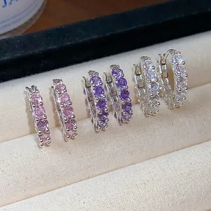 Exquisite shiny zircon hoop earrings in pink, purple, and clear stones on display tray.
