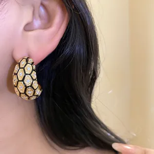 Detailed close-up of vintage 18k gold plated honeycomb earrings with zircons
