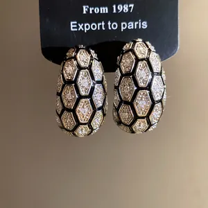 Detailed macro view of vintage 18k gold plated honeycomb earrings with pavé zircons