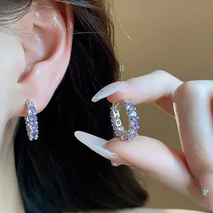 Close-up of sparkling purple zircon hoop earrings with elegant silver-colored finish