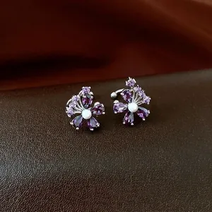 Elegant purple zircon flower ear cuff with pearl center on a dark leather base