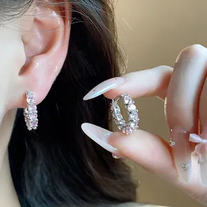 Macro detail of sparkly pink zircon hoop earrings showing delicate design and fit on ear.