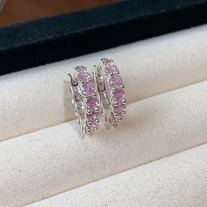 Detail view of dainty silver hoop earrings featuring brilliant pink round-cut cubic zircons