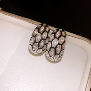Close-up of 18k gold plated earrings with hexagonal zircon honeycomb pattern