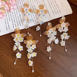 Elegant vintage floral tassel earrings with gold leaf accents and pearls, white petals