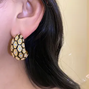 Detailed view of 18k gold plated honeycomb hoop earrings with zircon pavé on model.