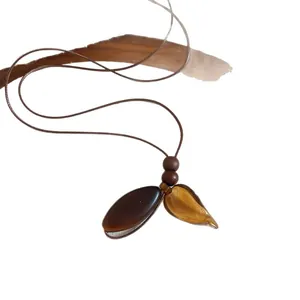 Vintage ethnic resin and wood beaded pendant necklace with a brown leather cord
