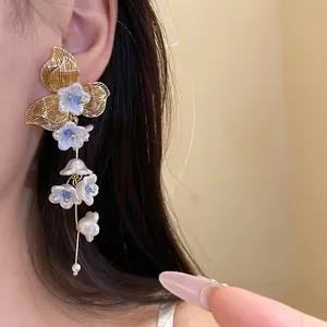 Vintage pearl flower tassel earrings with golden leaf design and blue crystal accents.