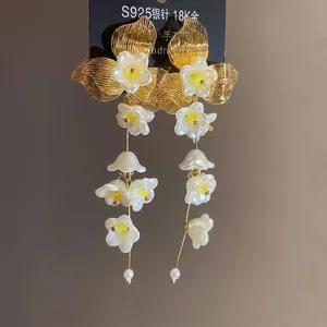 Elegant floral tassel earrings with pearlescent petals and gold-tone leaves on silver needles.