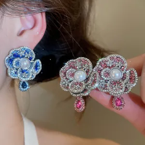 Elegant vintage camellia flower earrings featuring pearl center and sparkling crystal accents