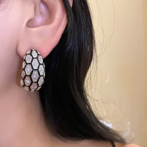 Detailed view of vintage gold plated zircon earrings with hexagonal honeycomb design.