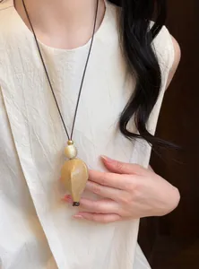 Detail view of retro artistic necklace with resin wood pendant and leather cord