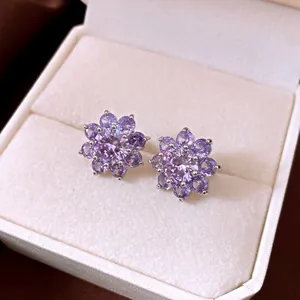 Detailed view of elegant purple zircon flower earrings in a cream jewelry box