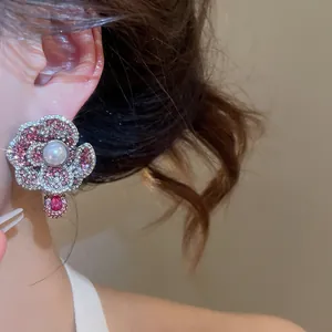 Detailed close-up of New Chinese style vintage floral pearl earrings with pink rhinestone inlay