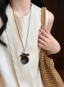 Detailed view of a vintage-style long necklace with resin and wooden beads on a model