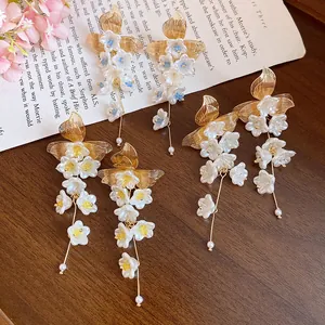 Detailed shot of vintage floral tassel earrings with white pearls and gold leaves