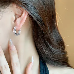 Detailed macro shot of elegant pink zircon hoop earrings with black accents on a model