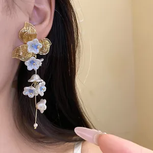 Detailed view of elegant pearl flower tassel earrings with golden leaf design