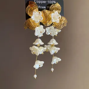 Detail view of vintage floral drop earrings featuring 100% copper and elegant pearl flowers.