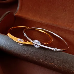 Close-up of vintage gold and silver bracelets featuring sparkling zircon stone settings