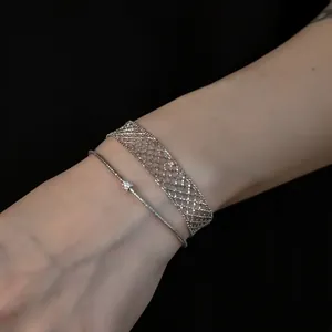 Elegant layered silver mesh grid bracelet and minimalist thin cable bangle on wrist